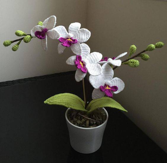 crocheted orchid flowers in corner-min vase