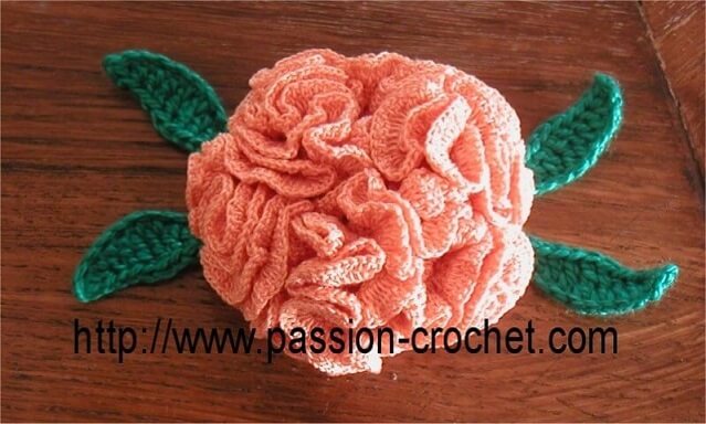 Pink crochet flower with green leaves