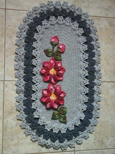 Oval crochet rug with two pink flowers