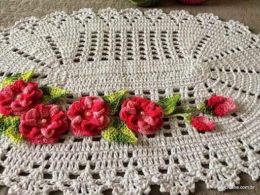 Oval crochet rug with pink flowers with pearl button