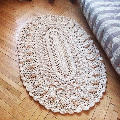 Oval crochet rug beside the bed