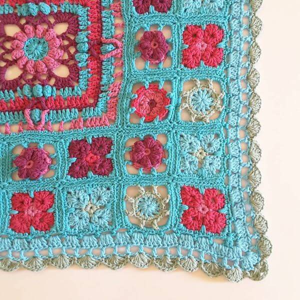 Square crochet rug with blue and red flower