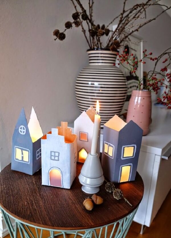 Crafts with milk cartons imitate houses and serve as a candle holder