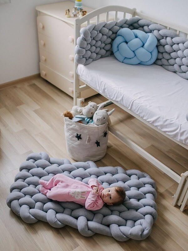 Gray blanket knot cushion complements baby room decor
