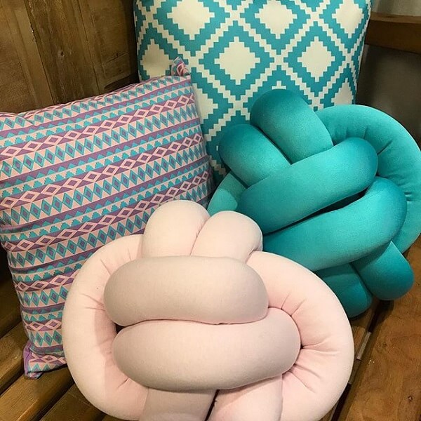 Knot cushion in light pink and turquoise blue decorate the room