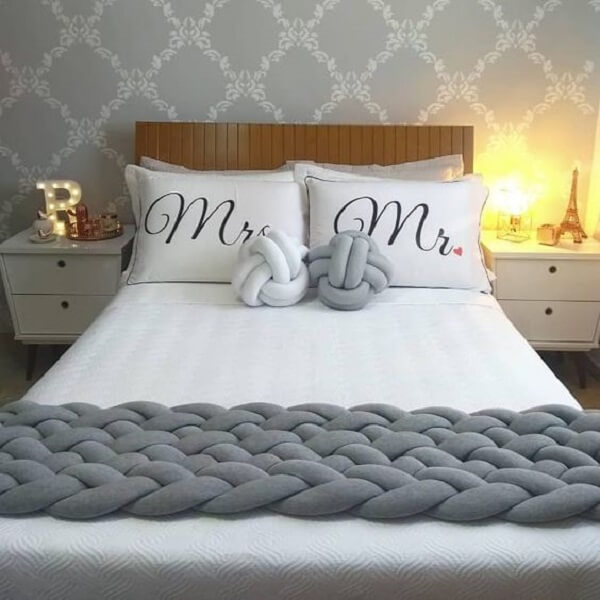 White and gray knot cushions blend with the decor of the double bedroom