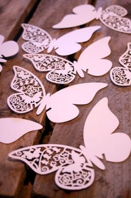 White paper butterflies with cut-out designs in stylus