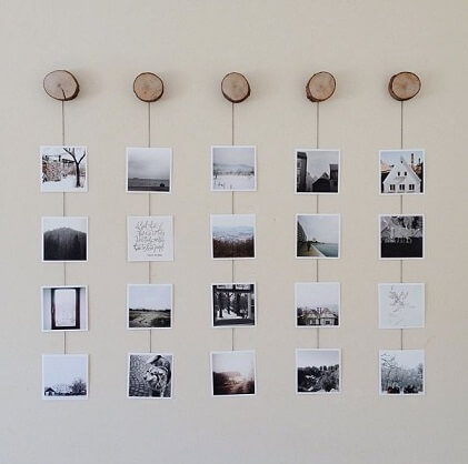 Varal de fotos penduradas em tocos de madeira