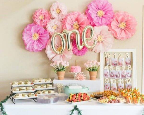 Decoração de festa com flores de papel de seda em tons de rosa