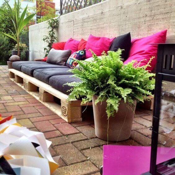 Jardim com sofá de palete preto e rosa