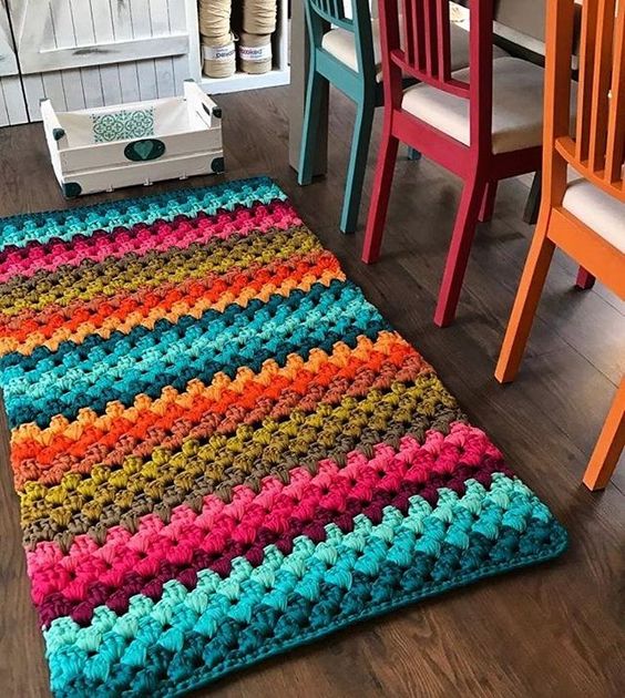 Tapete artesanal colorido combinando com as cadeiras