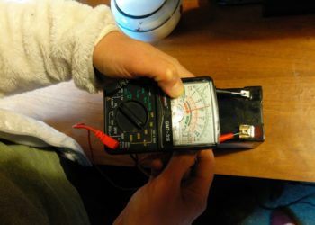 How do you test a fence charger with a multimeter?