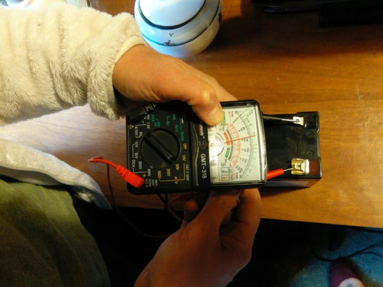 How do you test a fence charger with a multimeter?