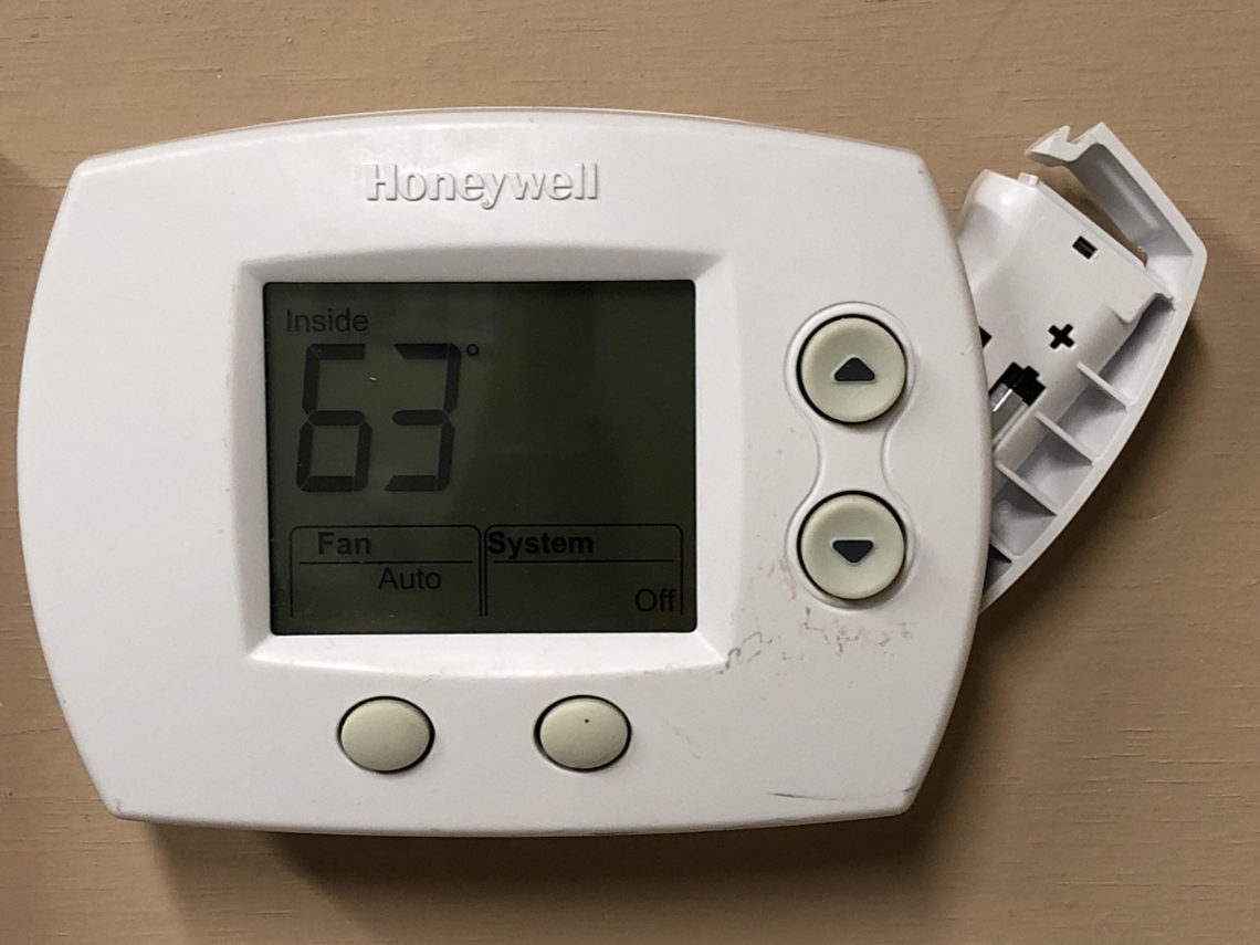 How do I replace the battery in my Honeywell thermostat?