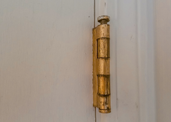 What causes black dust from door hinges?
