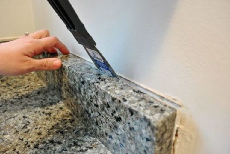 How do you remove a granite backsplash without damaging countertops?