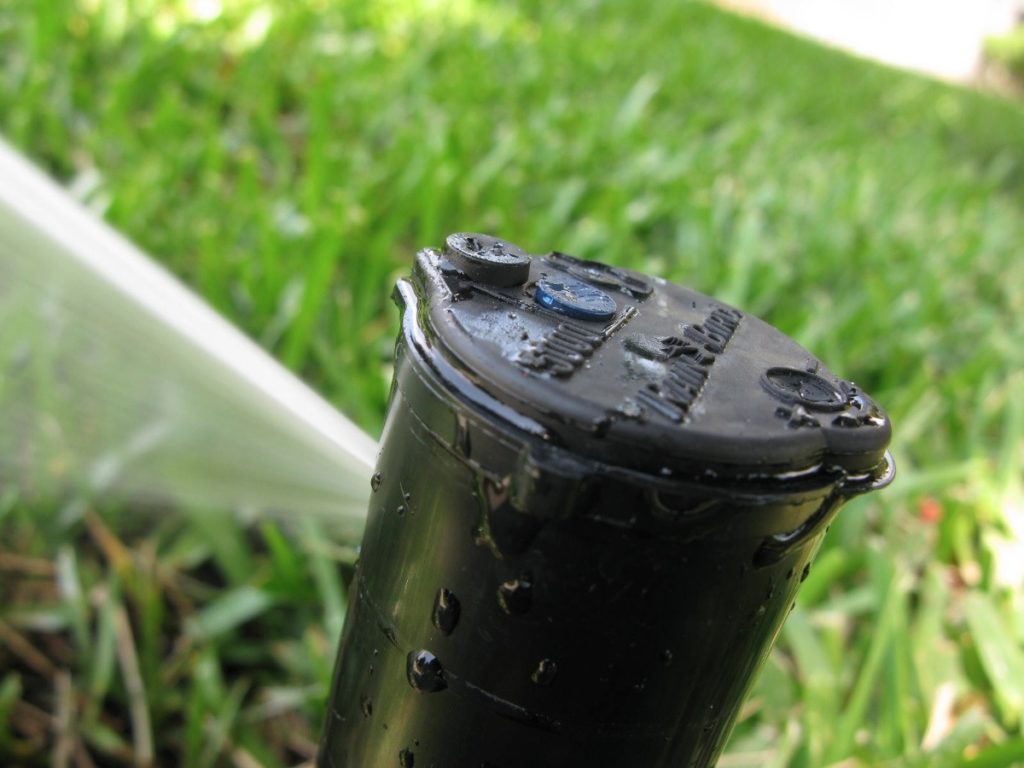 How do you rotate a Rainbird sprinkler head?