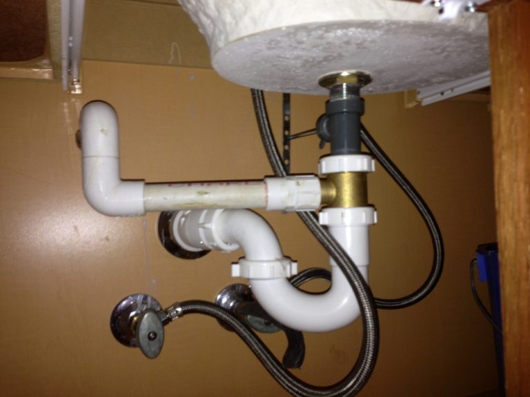 How do you unclog an AC drain line under the sink?