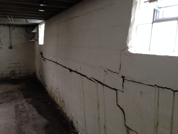 What is the proper fix for a bowing basement wall?